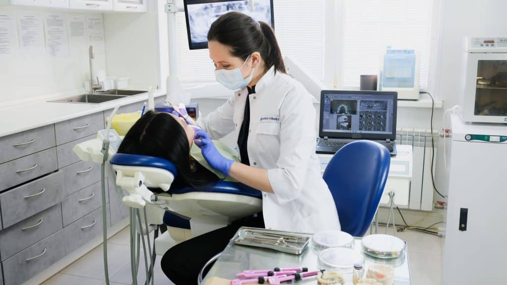 ön diş dolgusu için detaylı muayene yapan bir doktor